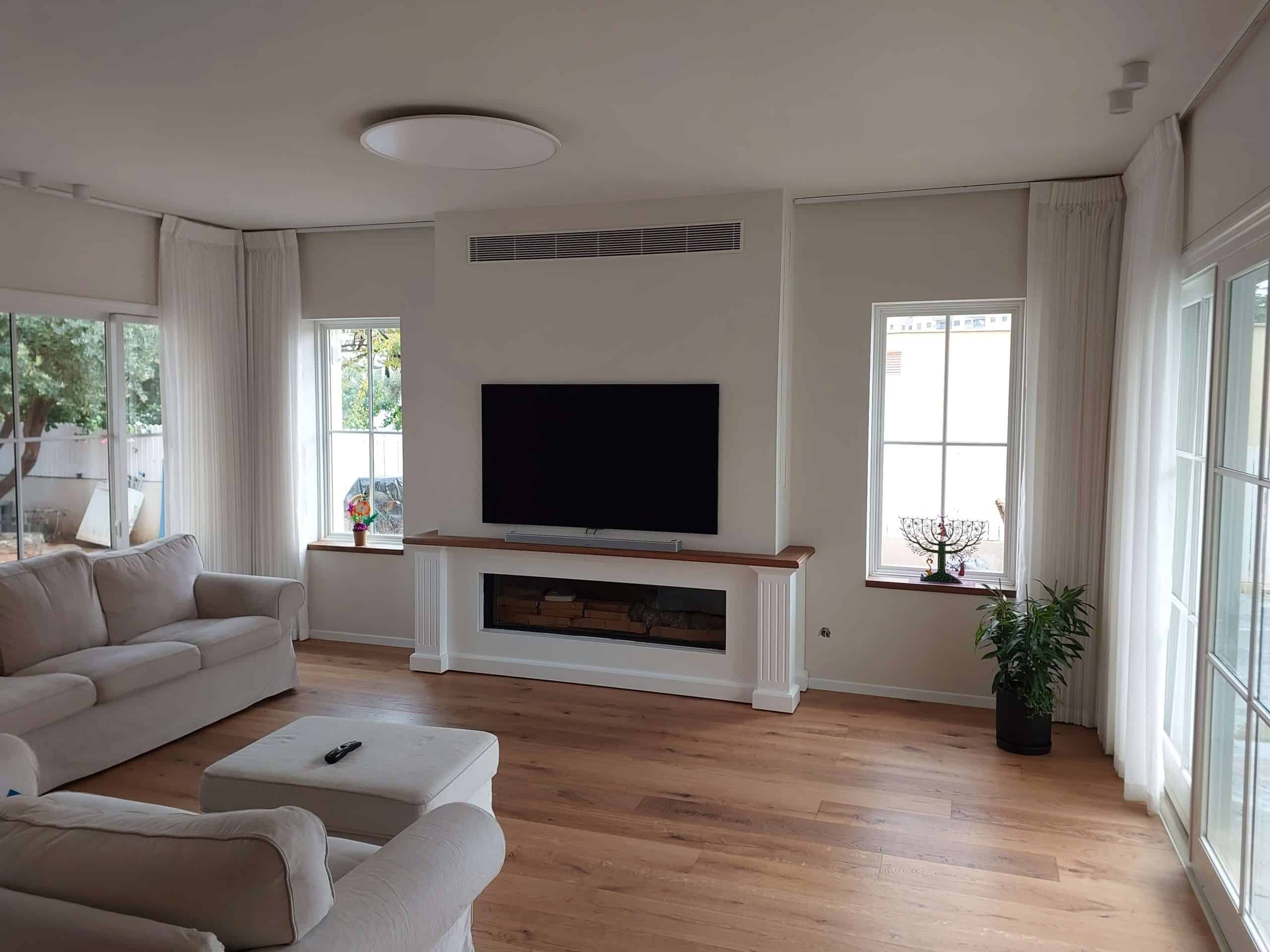 התקנת מערכת vrf פוג'יטסו בסלון עם יחידת מיזוג נסתרת מעל הטלוויזיה