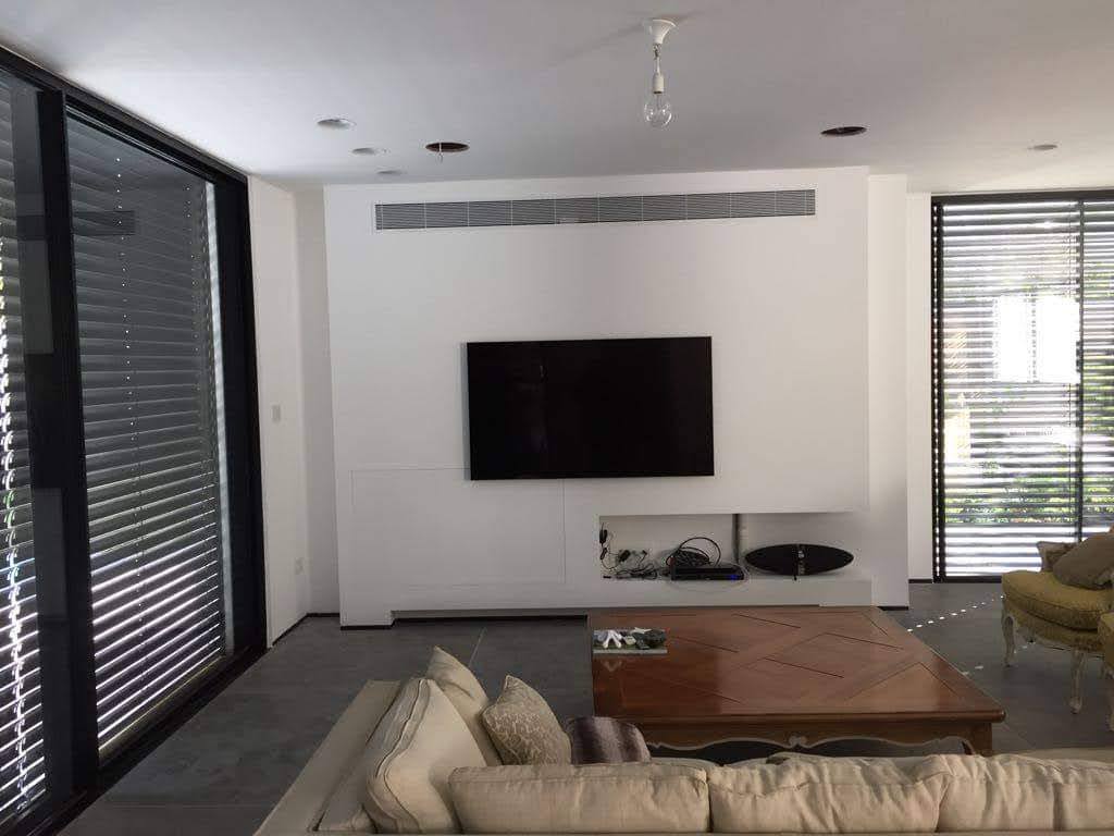 התקנת מערכת vrf פוג'יטסו בסלון עם יחידת מיזוג נסתרת מעל אזור הטלוויזיה